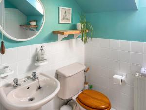 een badkamer met een toilet, een wastafel en een spiegel bij Chy An Mordros in Hayle