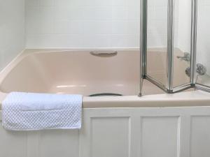 een wit bad met een douche en een handdoek bij Chy An Mordros in Hayle