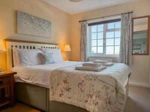 ein Schlafzimmer mit einem Bett mit Handtüchern darauf in der Unterkunft Primrose Cottage - Uk49219 in Burythorpe + 10 Fotos