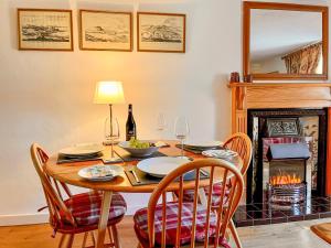 a dining room with a table and a fireplace at The Old Baron's Courthouse in Ceres