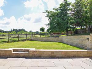 a park with a retaining wall and a fence at Doorstones Cottage in Moorside