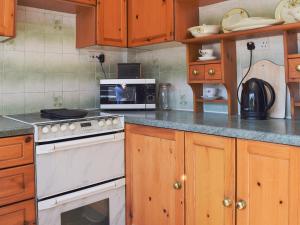 cocina con fogones blancos y microondas en Leanda Lodge, en Belton
