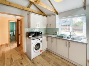 a kitchen with a washing machine and a sink at Parade - Uk49713 in Greatstone