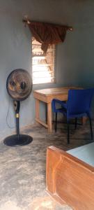 a room with a table and a fan and a chair at Savannah Lodge in Larabanga +23 photos