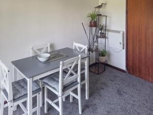 ein Tisch und Stühle in einem Raum mit einem Kühlschrank in der Unterkunft Strawberry Hill in Hayle