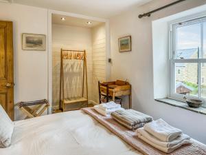 une chambre avec un lit avec des serviettes dessus dans l'établissement Owl Cottage, à Middleton in Teesdale