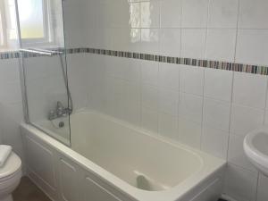 ein weißes Badezimmer mit Badewanne und Toilette in der Unterkunft Hawthorn Apartment - Uk49283 in Woolfardisworthy + 16 Fotos