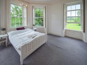a white bedroom with a bed and two windows at Escowbeck House in Lancaster +12 photos