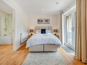 a bedroom with a large bed and a bathroom at Hole Farm - Stable Cottage in Shootend +8 photos