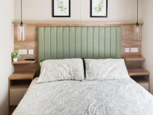 een bed met een groen hoofdeinde en 2 kussens bij Seaview One - Uk50167 in Corton