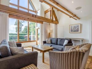 a living room with two couches and a table at Wittle Cottage in Quidenham