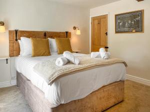 a bedroom with a large bed with towels on it at Wisteria Cottage in Harrogate +5 photos
