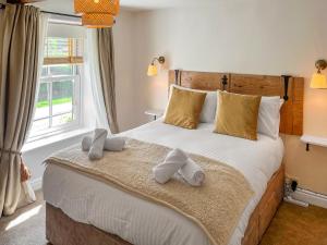 a bedroom with a large bed with towels on it at Wisteria Cottage in Harrogate