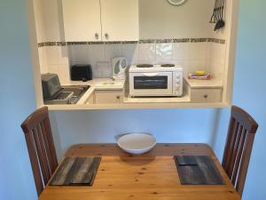 a small kitchen with a wooden table with a microwave at Hawfinch Apartment - Uk49304 in Woolfardisworthy