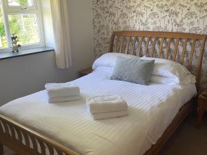 a bedroom with a bed with two towels on it at Hawfinch Apartment - Uk49304 in Woolfardisworthy