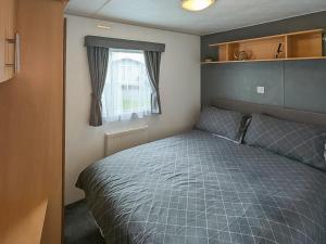 a small bedroom with a bed and a window at Amanda in Kinmel Bay