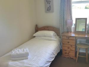 ein Schlafzimmer mit einem Bett und einem Schreibtisch mit Spiegel in der Unterkunft Chestnut Apartment - Uk49277 in Woolfardisworthy