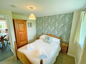 a bedroom with a bed and a wall with flowers at Bluebell Apartment - Uk49298 in Woolfardisworthy