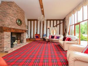 a living room with a brick fireplace and a red rug at Doves Barn in Needham Market