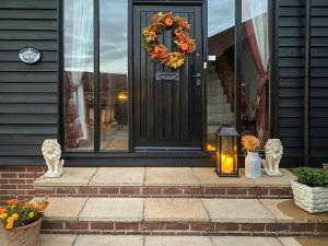 a front door of a house with a wreath and a lantern at Doves Barn in Needham Market