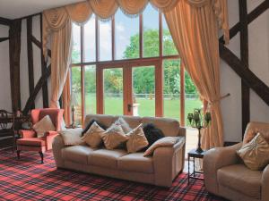 a living room with a couch and a large window at Doves Barn in Needham Market