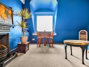 a living room with blue walls and a table and chairs at Sea View in Hollington