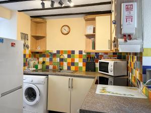 a kitchen with a sink and a microwave at Eastry Cottage in Castleton