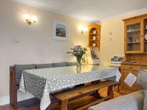 a dining room with a table with a vase of flowers on it at Eastry Cottage in Castleton +5 photos