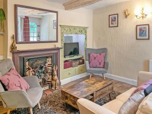 a living room with a fireplace and a mirror at Robins Nest in Leek