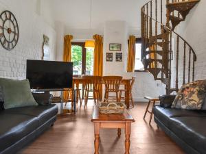 ein Wohnzimmer mit Sofa und Tisch in der Unterkunft Crooklets Cottage in Bude