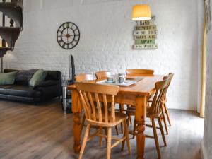 ein Esszimmer mit einem Holztisch und Stühlen in der Unterkunft Crooklets Cottage in Bude