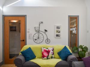 Una sala de estar con un sofá amarillo y una bicicleta en la pared. en Cowtons' Old Dairy, en East Cowton