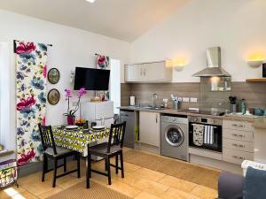 Una cocina con una mesa y sillas en una cocina. en Cowtons' Old Dairy, en East Cowton