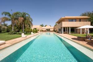 a swimming pool in front of a house at 2 Superbe villas avec chacune piscine privée & jardin 5 ou 6 chambres in Marrakech