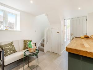 Una cocina y una sala de estar con un sofá y una mesa. en The Little House - Uk49129, en Stapleton