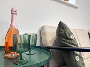Una botella de champán y dos copas en una mesa. en The Little House - Uk49129, en Stapleton