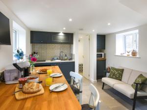 una cocina y una sala de estar con una mesa de madera con comida. en The Little House - Uk49129, en Stapleton