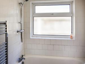 ein Bad mit einem Fenster und einer Badewanne in der Unterkunft Cosy Cottage in Manningtree + 6 Fotos