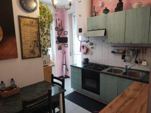 a kitchen with green cabinets and a sink and a table at Appartamento Chic Vista Lago - Casa Janis in Verbania