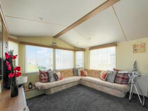 a large living room with a couch and windows at Cozee Stays in Rhyl