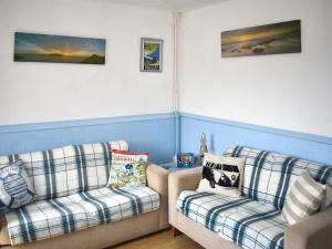 ein Wohnzimmer mit zwei Sofas und Gemälden an der Wand in der Unterkunft Surfers Halt in Woolacombe
