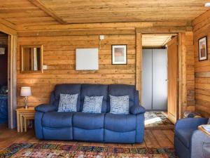 a blue couch in a living room with wooden walls at Alpaca Lodge in Acton