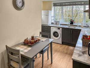 a kitchen with a table and a dishwasher at Bank Top Mews - Uk49214 in Wilsden