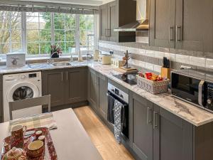 a kitchen with a sink and a stove top oven at Bank Top Mews - Uk49214 in Wilsden