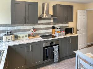 a kitchen with gray cabinets and a sink at Bank Top Mews - Uk49214 in Wilsden