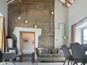 a living room with a couch and a brick wall at The Tractor Barn - Uk49678 in Bratton Fleming
