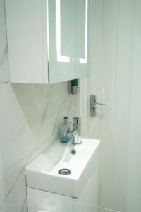 a white bathroom with a sink and a mirror at Concept Rooms 6 Central Enfield Town Station in Enfield +14 photos