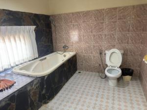 a bathroom with a bath tub and a toilet at Kata Palace Phuket Hotel in Kata Beach +37 photos