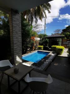 un cortile con piscina, tavolo e sedie di LA VILLA 1 Deluxe2 Mont Choisy MAURITIUS a Mont Choisy