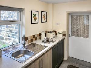 a kitchen with a sink and a counter top at Bank Top Cottage - Uk49215 in Wilsden